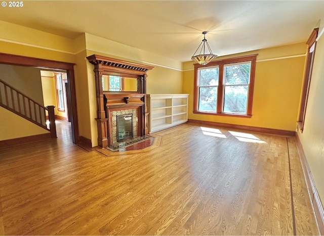 812 SW Saint Clair Ave Unit 3, Portland, OR 97205 - unfurnished living room with baseboards, wood finished floors, stairs, and a glass covered fireplace