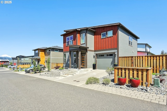 1250 29th St, Hood River, OR 97031 - modern home with an attached garage, board and batten siding, fence, and driveway