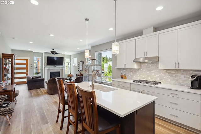 1250 29th St, Hood River, OR 97031 - kitchen with ceiling fan, a sink, decorative backsplash, stainless steel gas stovetop, and under cabinet range hood
