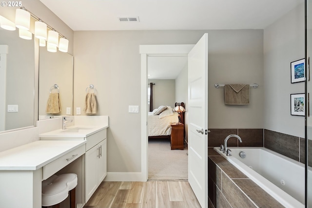 1250 29th St, Hood River, OR 97031 - full bathroom featuring a garden tub, visible vents, wood finished floors, vanity, and ensuite bath