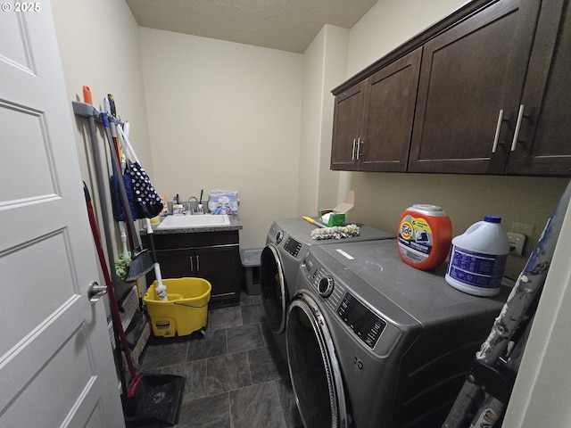 washroom with sink, cabinets, and washer and dryer