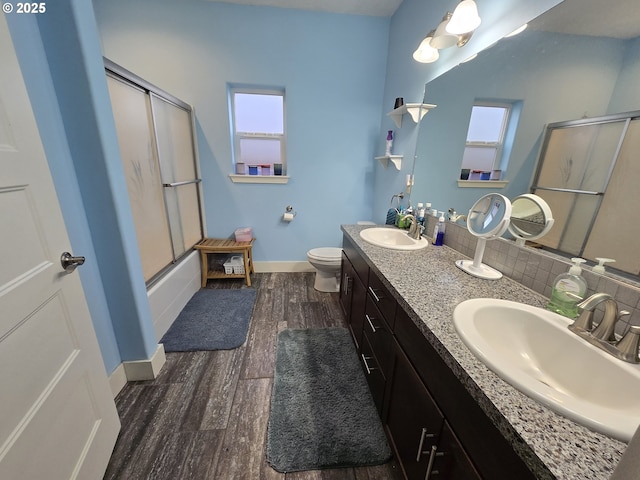 full bathroom featuring decorative backsplash, enclosed tub / shower combo, a healthy amount of sunlight, and hardwood / wood-style flooring