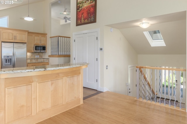 2965 Ingalls Way, Eugene, OR 97405 - kitchen with appliances with stainless steel finishes, a skylight, high vaulted ceiling, light brown cabinets, and wood finished floors