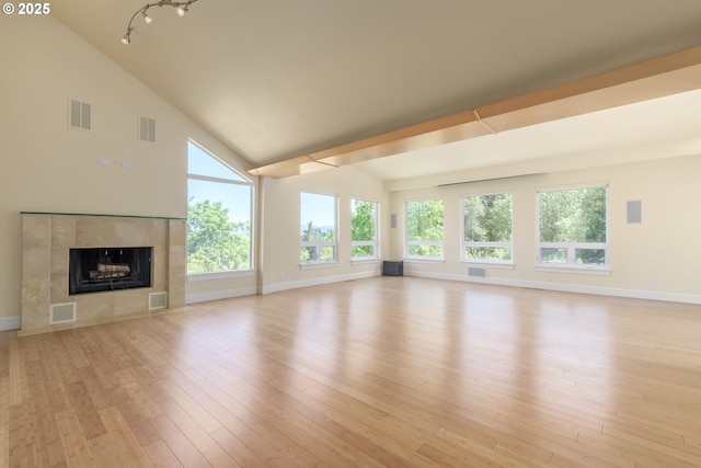 2965 Ingalls Way, Eugene, OR 97405 - unfurnished living room with healthy amount of natural light, light wood-style flooring, a tile fireplace, and high vaulted ceiling