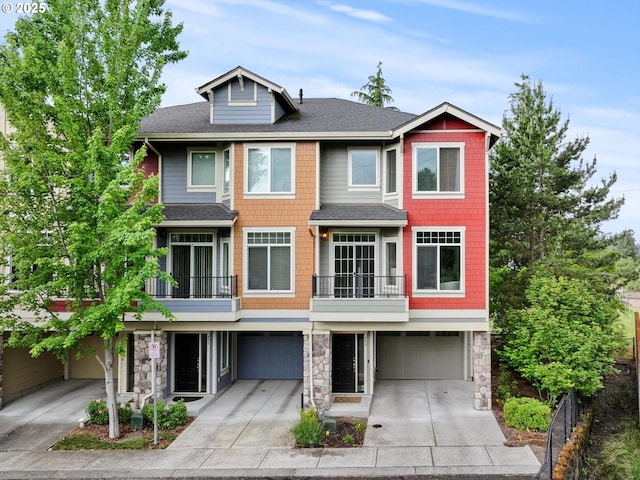 multi unit property featuring an attached garage, driveway, roof with shingles, and stone siding