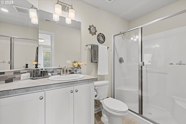 bathroom with a stall shower, toilet, and vanity