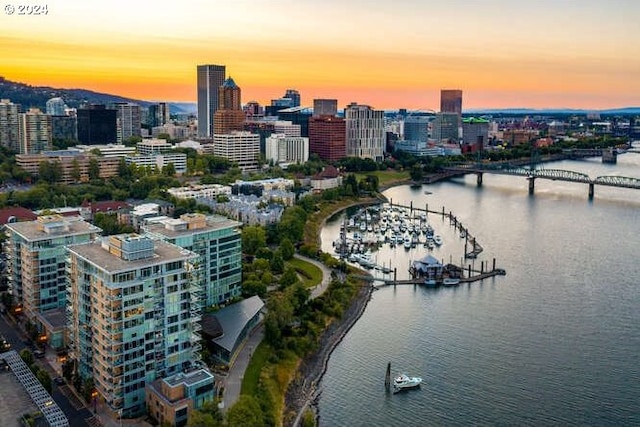 aerial view at dusk of a water view, a notable bridge, and a city view