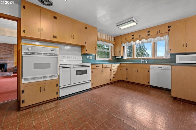 kitchen with sink, white appliances, and a brick fireplace