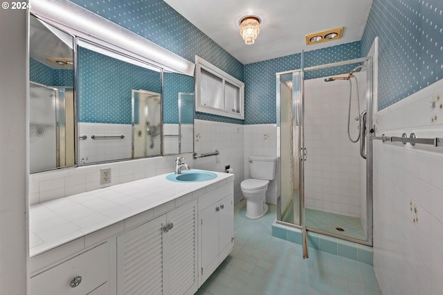 bathroom featuring tile patterned flooring, a shower with door, vanity, and toilet