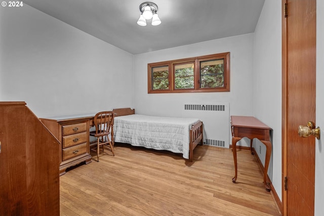 bedroom featuring radiator and light hardwood / wood-style flooring