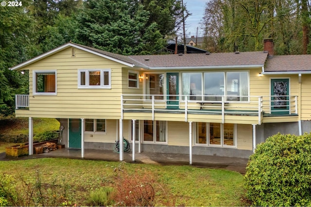 rear view of house featuring a patio area, a balcony, and a yard