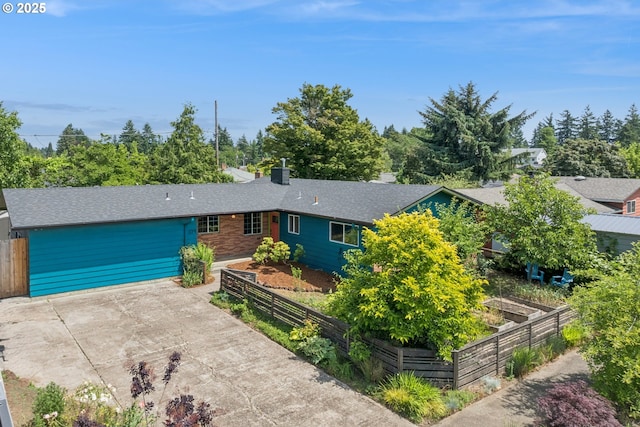 324 NE 108th Pl, Portland, OR 97220 - view of front of house featuring a patio, a garden, roof with shingles, a chimney, and driveway