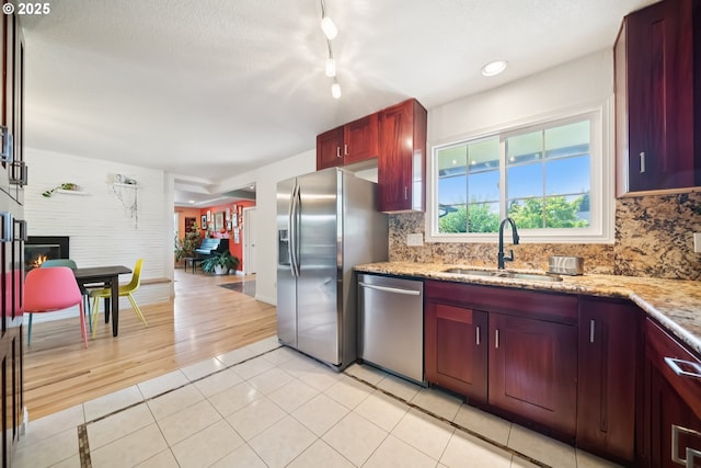 324 NE 108th Pl, Portland, OR 97220 - kitchen with stainless steel appliances, dark brown cabinets, decorative backsplash, light tile patterned flooring, and light stone counters