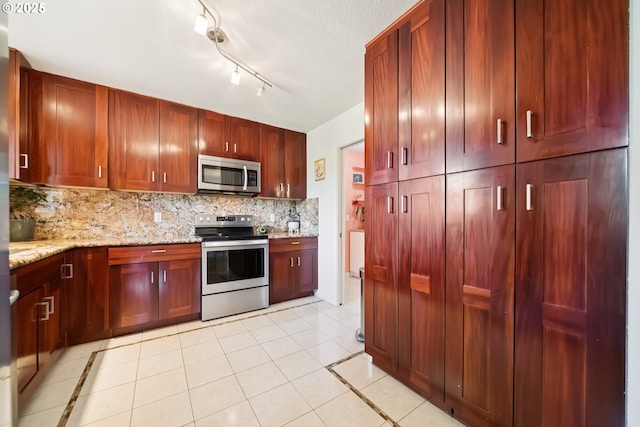324 NE 108th Pl, Portland, OR 97220 - kitchen featuring stainless steel appliances, dark brown cabinets, tasteful backsplash, and light stone countertops