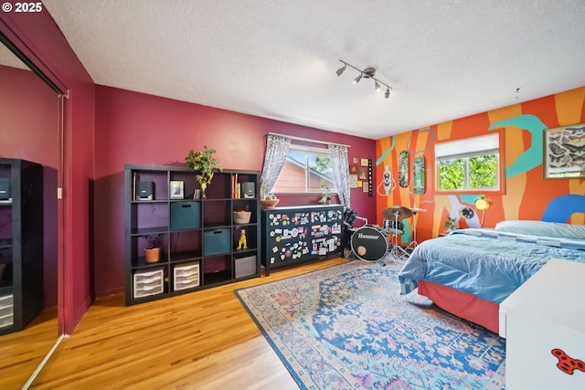 324 NE 108th Pl, Portland, OR 97220 - bedroom with a textured ceiling, wood finished floors, and multiple windows