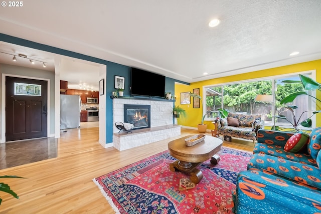 324 NE 108th Pl, Portland, OR 97220 - living room featuring wood finished floors, a fireplace, recessed lighting, and a textured ceiling