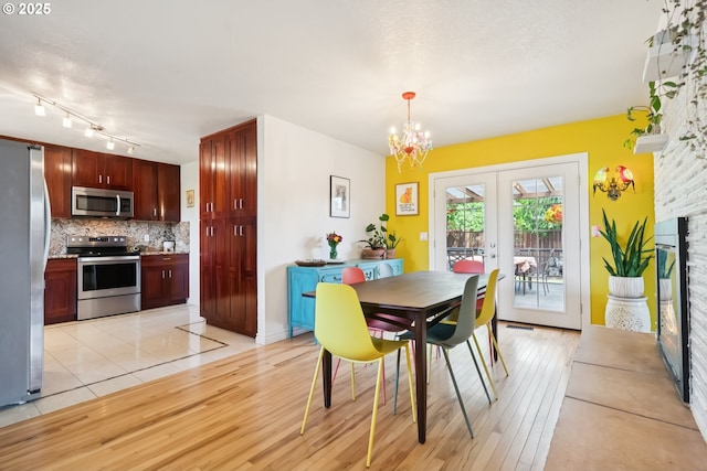324 NE 108th Pl, Portland, OR 97220 - dining space with french doors, light wood finished floors, and a chandelier