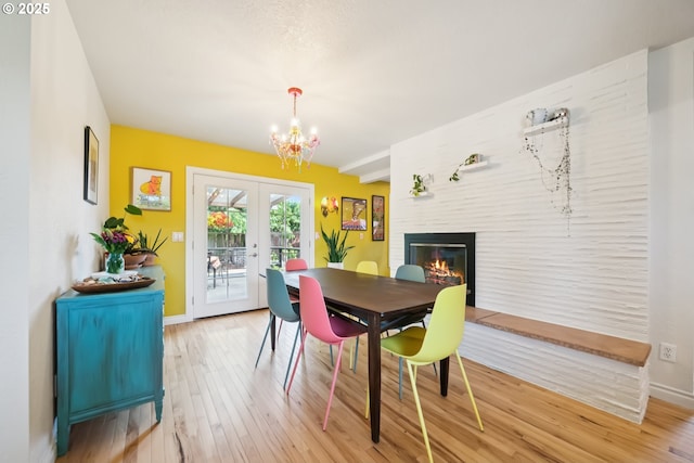 324 NE 108th Pl, Portland, OR 97220 - dining room with french doors, light wood-style floors, a chandelier, and a large fireplace