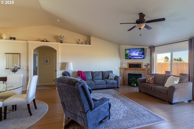 2260 NE 8th St, Hermiston, OR 97838 - living area featuring lofted ceiling, ceiling fan, arched walkways, a tiled fireplace, and wood finished floors