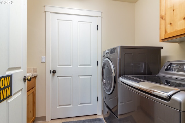 2260 NE 8th St, Hermiston, OR 97838 - laundry room with washing machine and clothes dryer, cabinet space, and light tile patterned floors