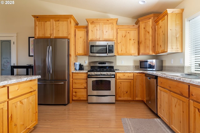 2260 NE 8th St, Hermiston, OR 97838 - kitchen featuring appliances with stainless steel finishes, lofted ceiling, light countertops, light wood finished floors, and light brown cabinets