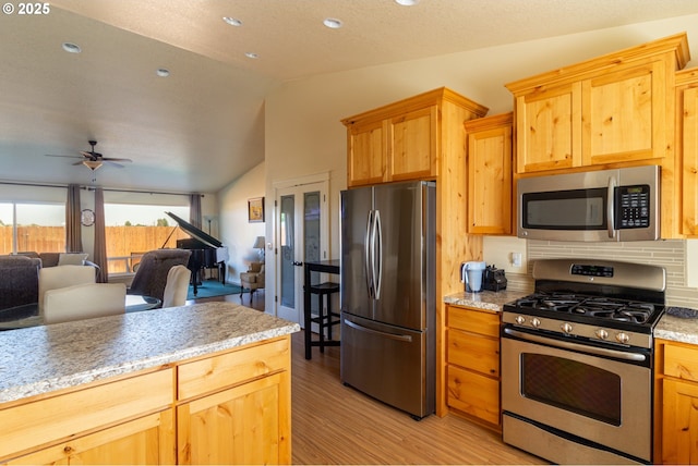 2260 NE 8th St, Hermiston, OR 97838 - kitchen featuring appliances with stainless steel finishes, lofted ceiling, light wood-style flooring, a ceiling fan, and open floor plan