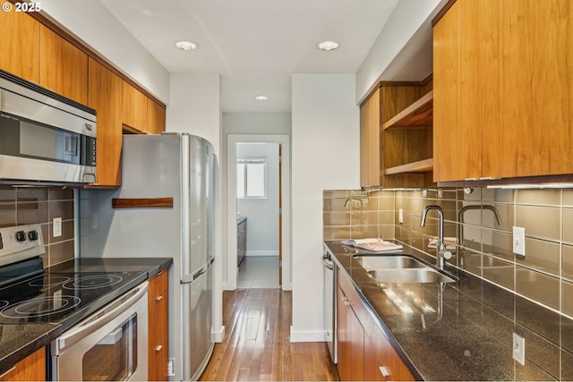 1912 SE 11th Ave Unit 3, Portland, OR 97214 - kitchen with appliances with stainless steel finishes, a sink, brown cabinets, open shelves, and baseboards