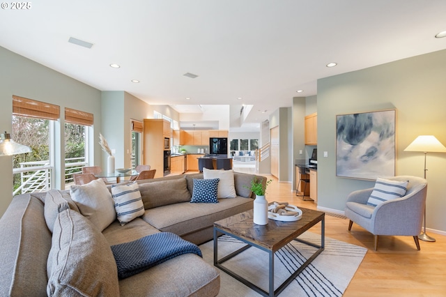 living room with visible vents, recessed lighting, baseboards, and light wood finished floors