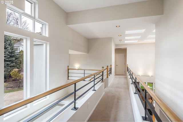 hall featuring recessed lighting, an upstairs landing, and light carpet