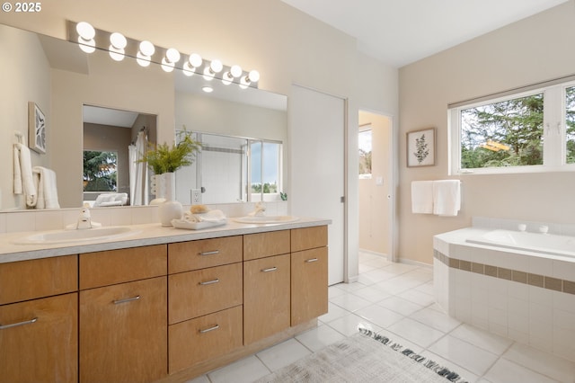 bathroom with a sink, a bath, double vanity, and tile patterned floors