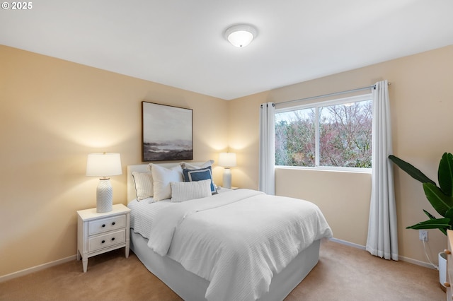 bedroom featuring light colored carpet and baseboards