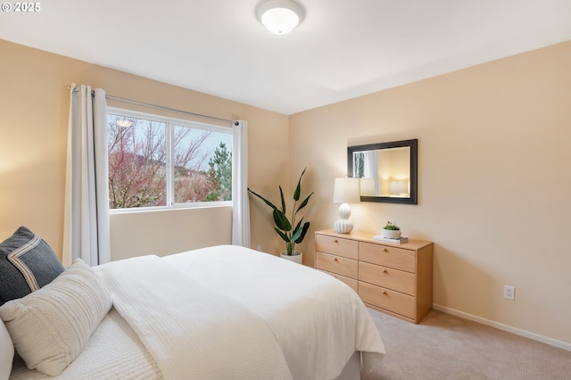 bedroom featuring baseboards and light colored carpet