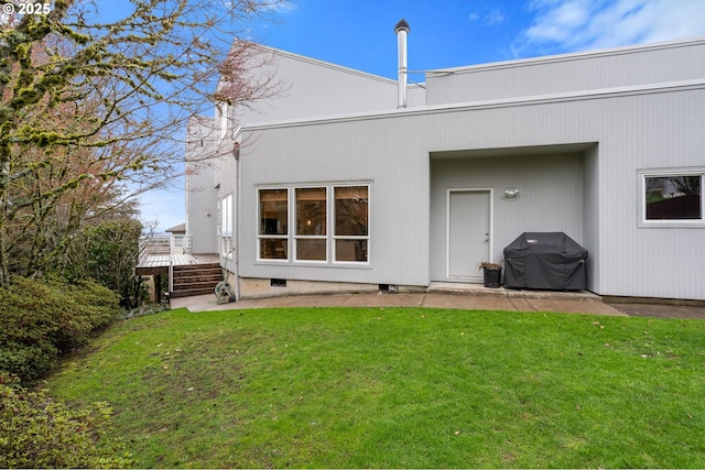 rear view of property featuring a deck, a lawn, and crawl space