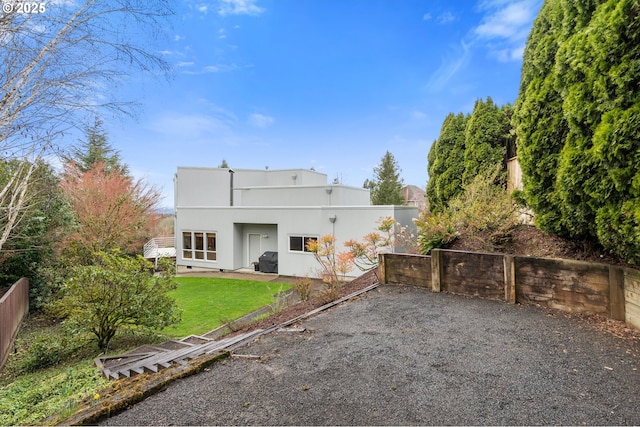 rear view of property featuring a patio area, a yard, a fenced backyard, and stucco siding