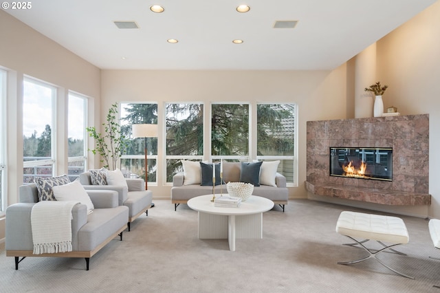 living room featuring recessed lighting, light carpet, and a tiled fireplace