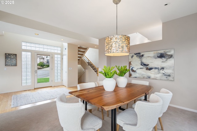 dining space with recessed lighting, stairway, baseboards, and light carpet