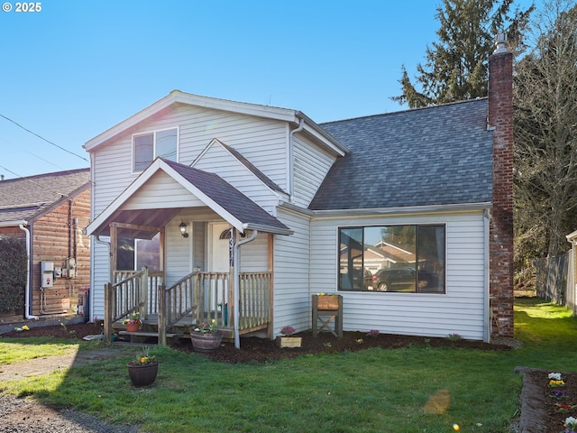 view of front of home featuring roof with shingles, fence, a chimney, and a front lawn