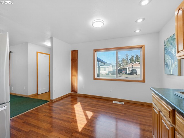 interior space featuring recessed lighting, visible vents, dark wood-type flooring, freestanding refrigerator, and baseboards