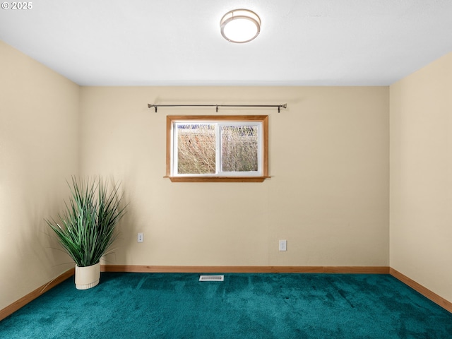 carpeted spare room featuring visible vents and baseboards