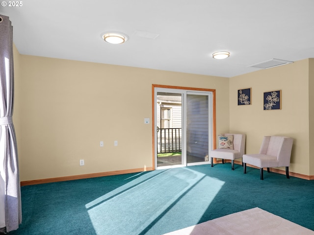 living area featuring carpet floors, attic access, and baseboards