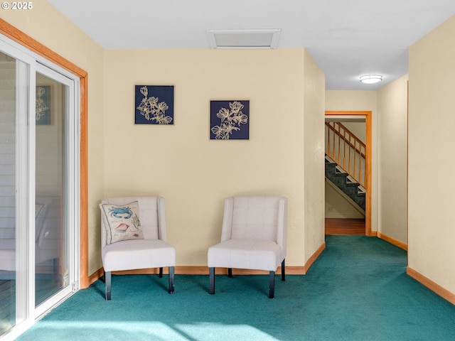 sitting room with stairs, carpet flooring, and baseboards