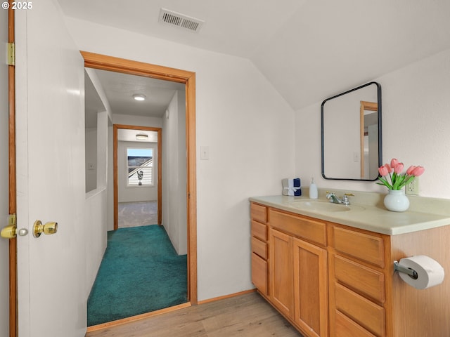 bathroom featuring lofted ceiling, visible vents, vanity, and wood finished floors