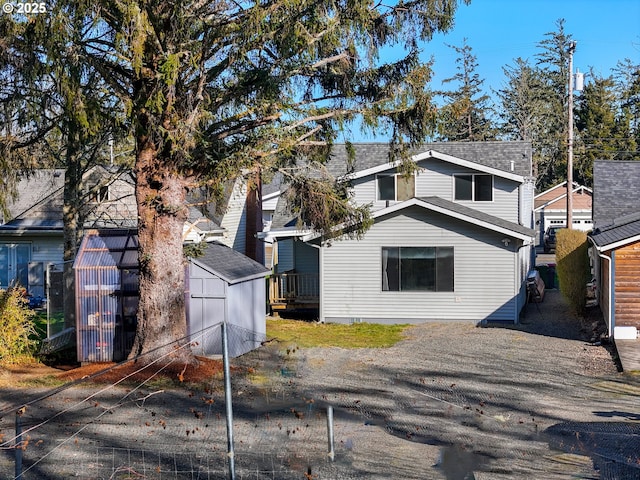 rear view of property featuring roof with shingles