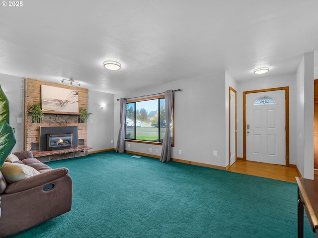 carpeted living area with a brick fireplace and baseboards