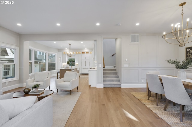 living room featuring a notable chandelier and light hardwood / wood-style flooring