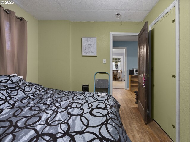 bedroom featuring a textured ceiling and wood finished floors