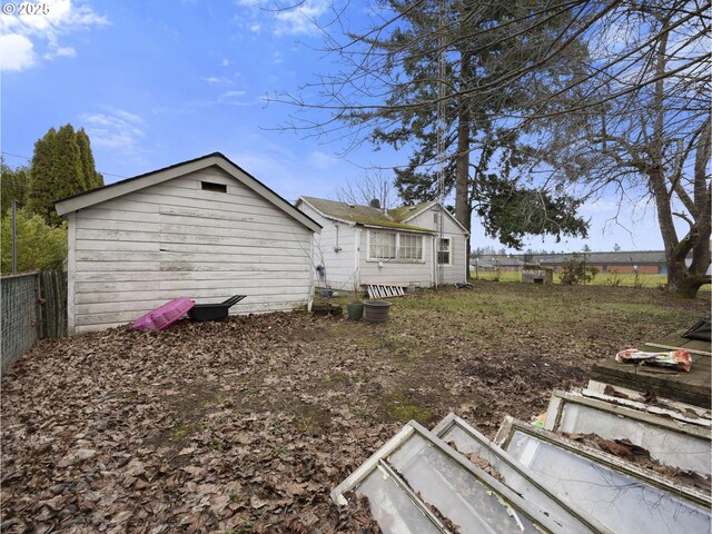 rear view of property featuring fence