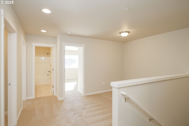 corridor featuring light colored carpet