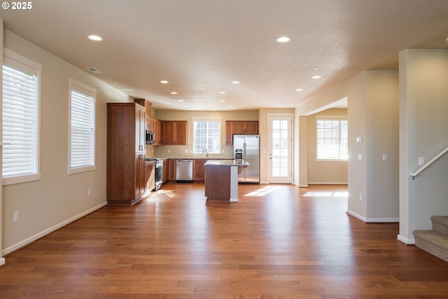 kitchen with wood-type flooring, sink, a center island, and stainless steel appliances