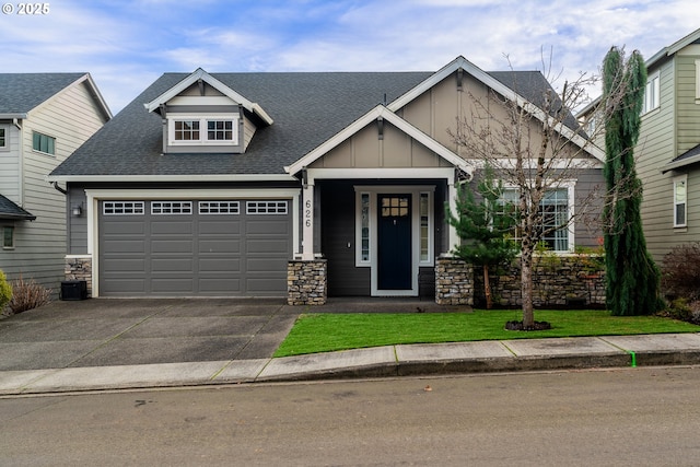 craftsman inspired home with a shingled roof, concrete driveway, an attached garage, board and batten siding, and stone siding